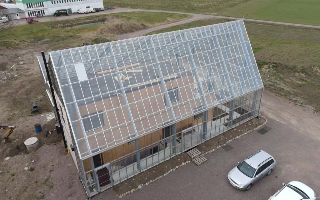 Asymmetrical glass building around house